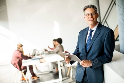 Visualização: Empresário bonito usando seu tablet no escritório