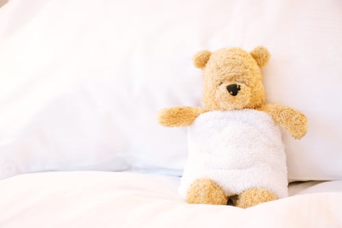 Preview: Lonely bear in bed on white pillow