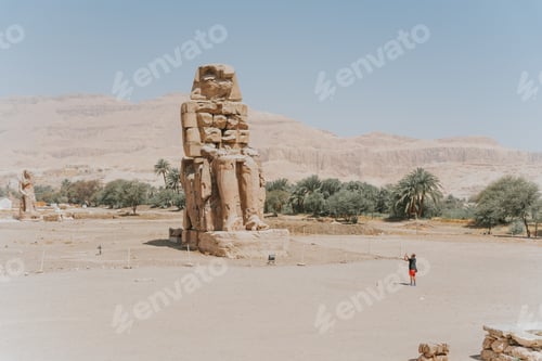 Preview: Tourist taking pictures of the colossi of memnon in luxor, egypt