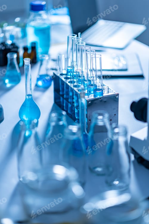 Preview: Different laboratory glassware with color liquid and with reflection, blue tone
