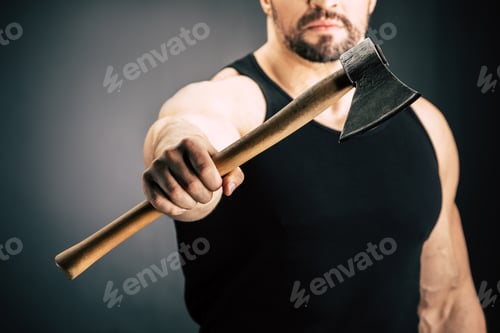 Preview: selective focus of sportive man showing axe in hand isolated on black