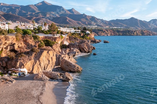Preview: Beautiful view of the blue sea and rocky shore of Nerja against the backdrop of mountains. Spain.