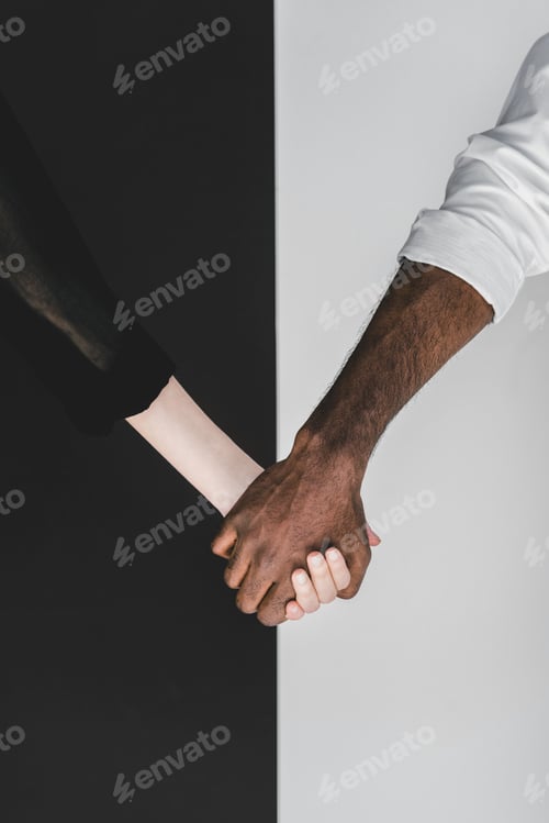Preview: cropped image of multicultural couple holding hands, yin yang concept
