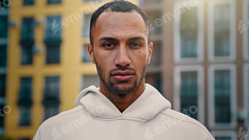 Preview: American latino man handsome male athletic muscular guy serious looking at camera stand on city