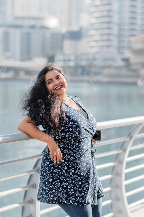 Preview: A young Indian woman is walking in the Dubai Marina area, enjoying a sunny day