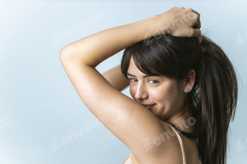 Preview: Woman Puts Hair Up in Ponytail Indoors