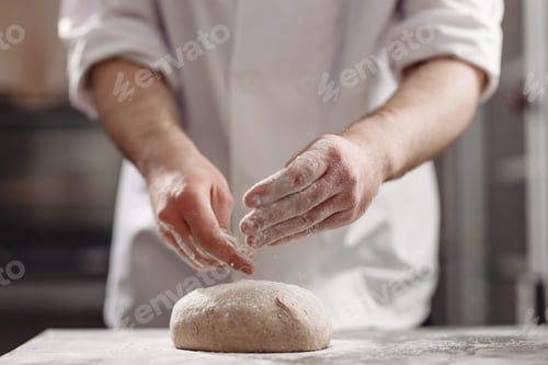 Preview: Baker kneads dough on the table in the bakery