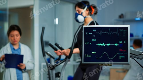 Preview: Monitor showing EKG scan of athlete running on cross trainer