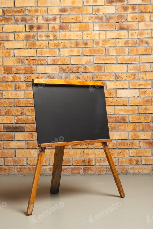 Preview: Black sign in wooden frame and copy space on brick wall background
