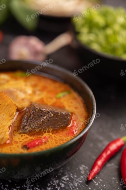 Preview: Chicken curry in a black cup.