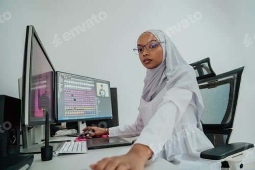 Preview: Young Afro-American modern Muslim businesswoman wearing a scarf in a creative bright office