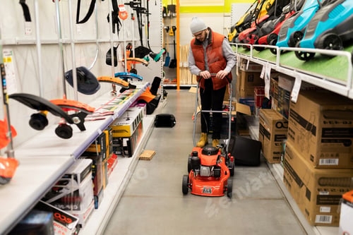 Preview: a customer in a store inspects an asteroid gas-powered lawn mower