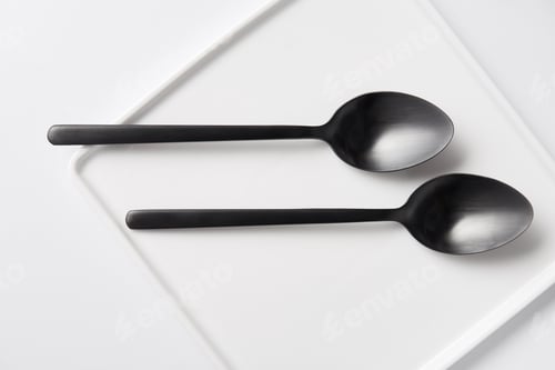 Preview: top view of two spoons and plate on white table, minimalistic concept