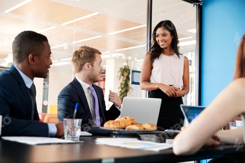 Preview: Businesswoman stands to address colleagues in a meeting room