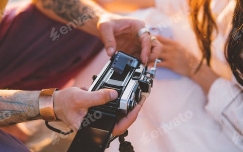 Couple Loading Film Into A Retro Camera