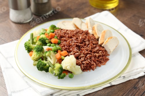 Preview: Delicious brown rice with chicken and vegetables served on wooden table, closeup