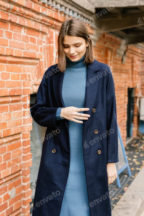 Preview: Young beautiful stylish woman walking in street in warm autumn outfit.