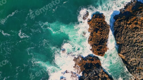 Preview: Stormy turquoise sea waves splashing at seashore cliffs. Aerial view seashore
