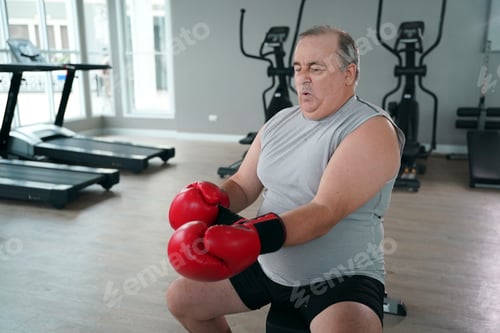 Preview: Older man practicing boxing techniques in a gym during morning workout session