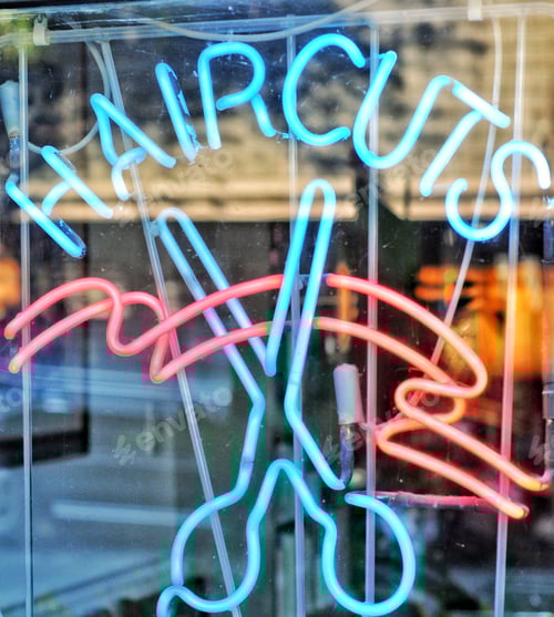 Preview: Neon Haircuts Sign Glowing in Urban Window