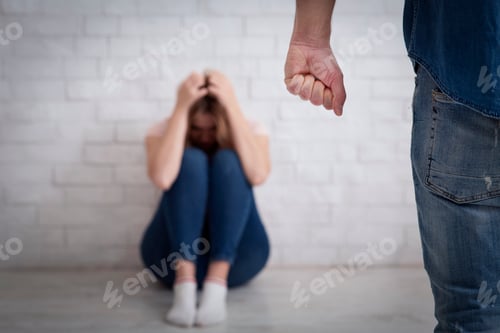 Preview: Domestic violence, tyranny and beating. Terrified woman covers her head with hands and sits on floor