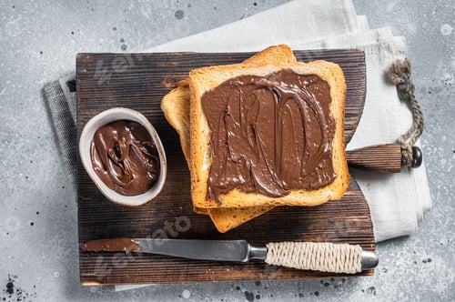 Preview: Toast with chocolate Hazelnut spread on wooden board. Gray background. Top view