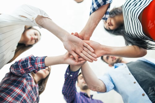 Preview: Young business people putting their hands together