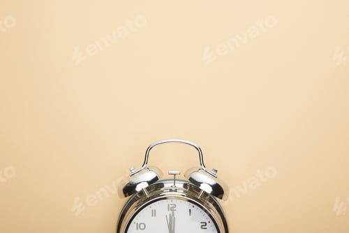 Preview: top view of classic alarm clock on beige background