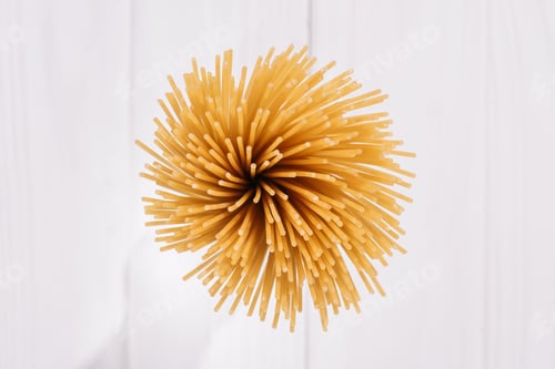Preview: top view of bunch of raw spaghetti on white wooden surface