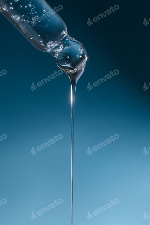 Preview: Pipette with transparent serum on the background of shells.
