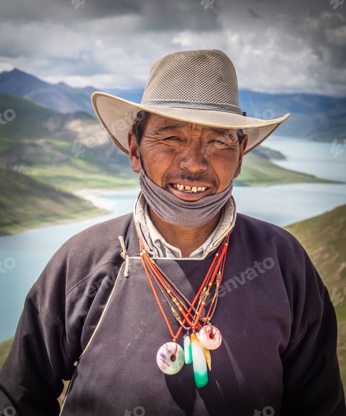 Preview: Tibet - August, 29 2014: Ethnic man near river and hills