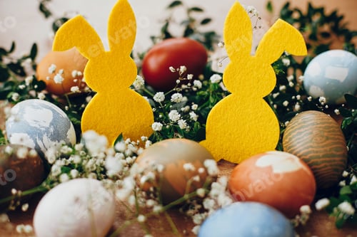 Preview: Stylish easter eggs and yellow bunny on rustic wooden table