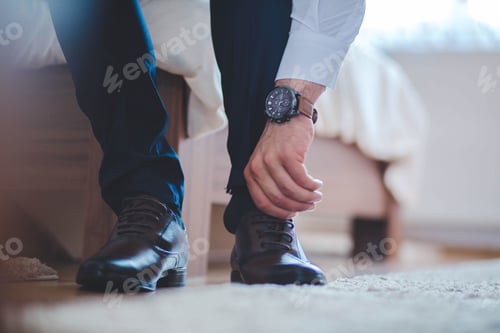 Preview: Selective focus shot of a man wearing his shoe on