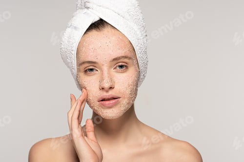 Preview: beautiful girl with towel on head applying coconut scrub on face, isolated on grey