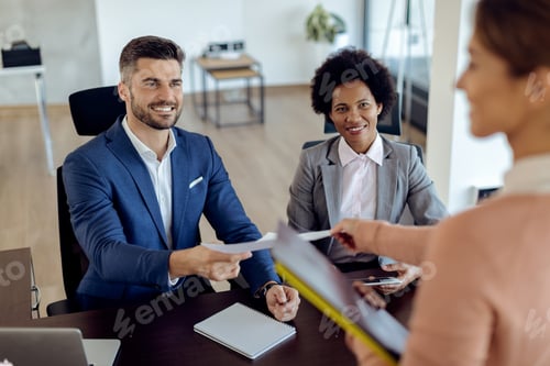 Preview: Happy human resource team taking CV from potential candidate during job interview.