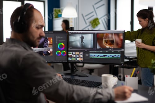 Preview: Video maker with headset working with footage and sound on pc with two displays