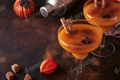 Preview: Pumpkin cocktail with cinnamon, orange juice and cocoa in glass mugs. Pumpkin autumn drink for Hallo