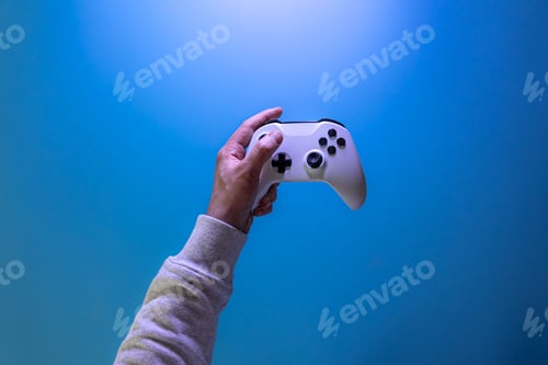Preview: Male hands hold a gamepad on a blue background, copy space.
