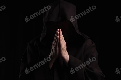 Preview: front view of mysterious anonymous monk with praying hands isolated on black