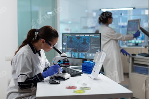 Preview: Specialist biologist researcher analyzing biomedical virus sample using medical microscope