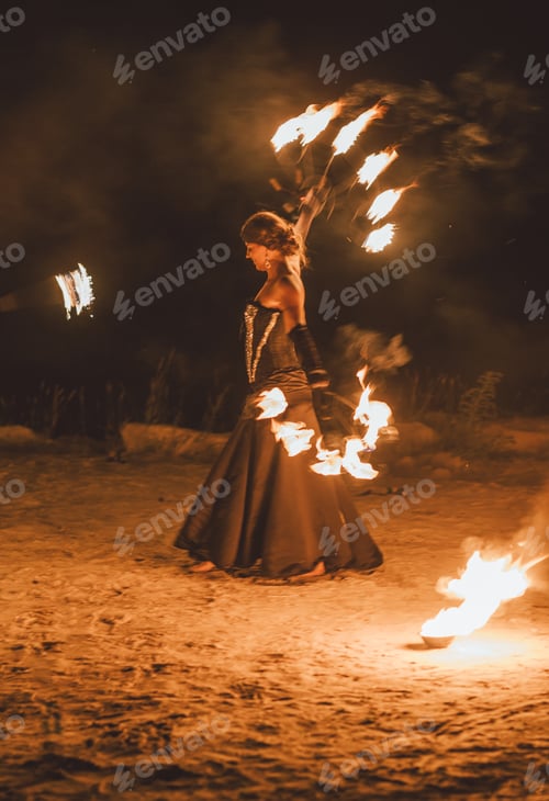 Preview: Young brunette woman in black dress showing a fire show, performance
