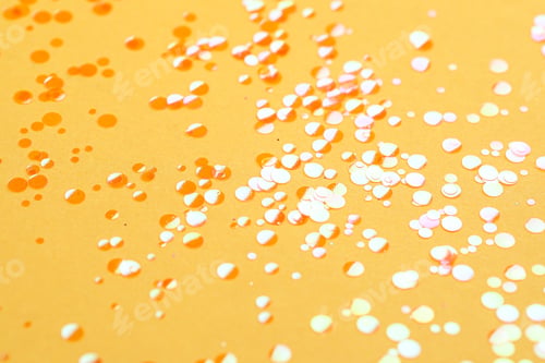 Preview: Shiny bright orange glitter on yellow background, closeup