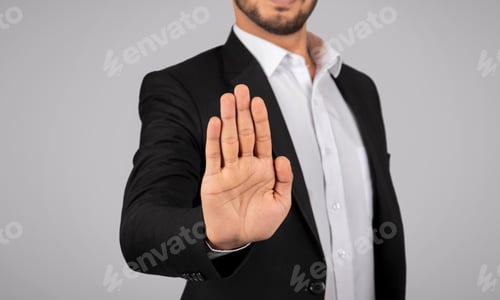 Preview: Young Businessman Showing Stop Gesture With Open Palm At Camera