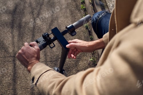 Preview: Unrecognizable man using display of scooter