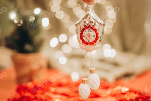 Preview: Christmas toy on a tree in the form of a clock on a bokeh background