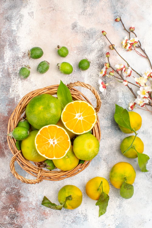 Preview: top view fresh mandarines in wicker basket mandarines feykhoas on nude background