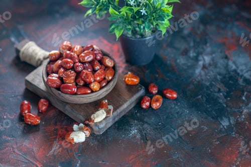 Preview: Top view of fresh raw silverberry fruits in a bowl on a wooden cutting board and flower pot on the