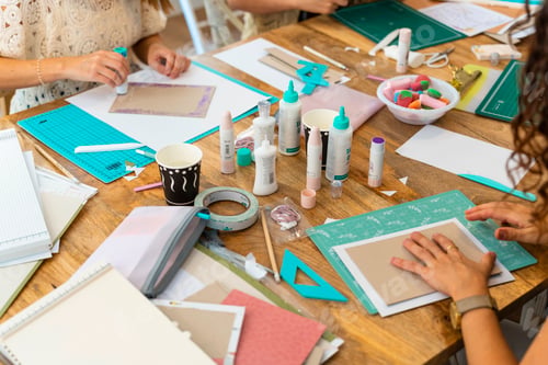 Preview: Scrapbook workshop. Women working on their album with glue and cutouts