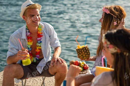 Preview: Group of multiethnic friends enjoying Hawaiian party on summer vacation.