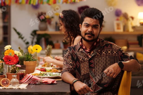 Preview: Young bearded man in ethnic shirt
